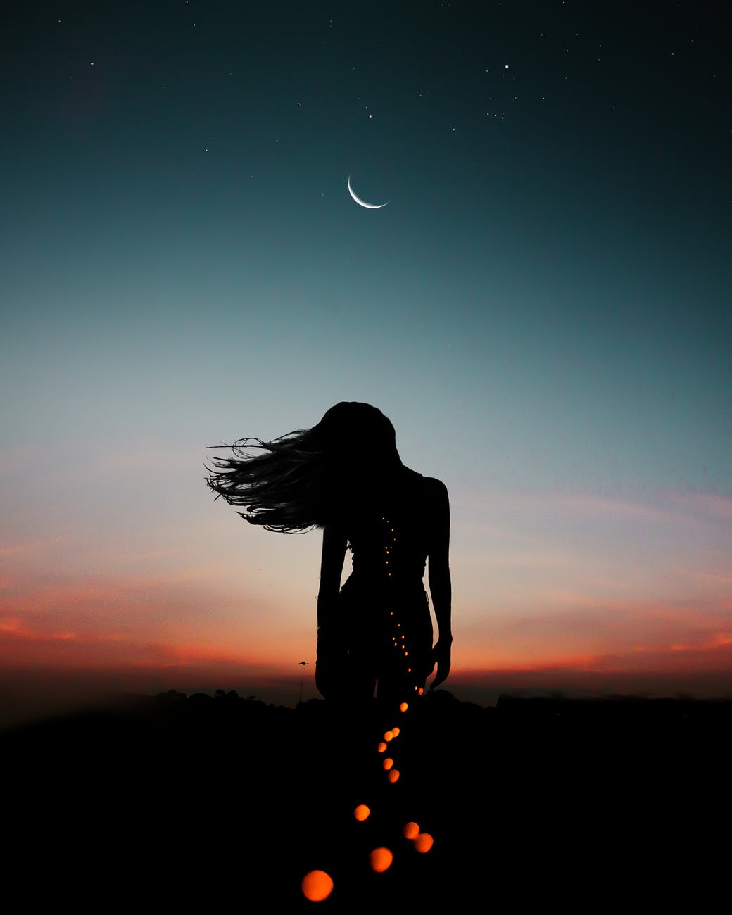 silhouette of person under crescent moon